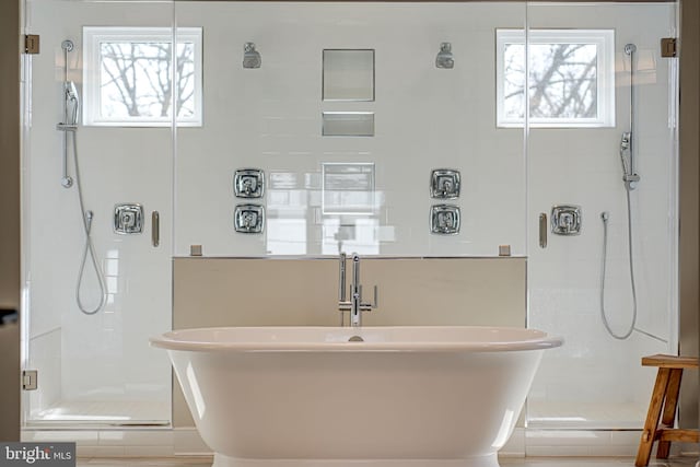 full bath with a sink, a soaking tub, and a stall shower