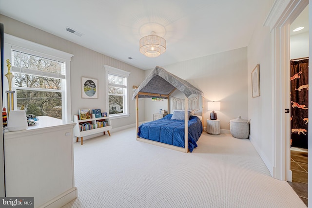 carpeted bedroom featuring baseboards and visible vents