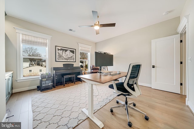 office featuring a wealth of natural light, light wood-type flooring, and ceiling fan