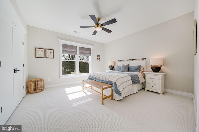 bedroom with ceiling fan, light colored carpet, visible vents, and baseboards