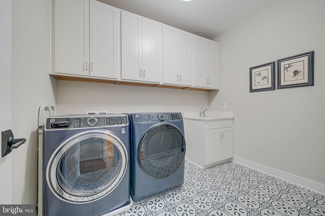 laundry room featuring baseboards, light tile patterned floors, separate washer and dryer, cabinet space, and a sink