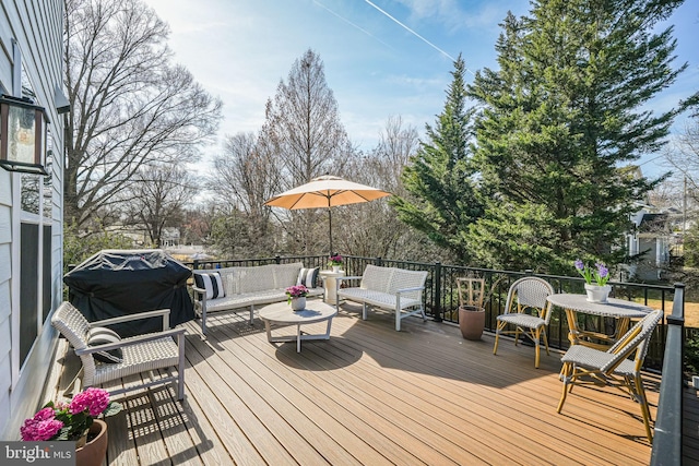 wooden deck with area for grilling and an outdoor hangout area