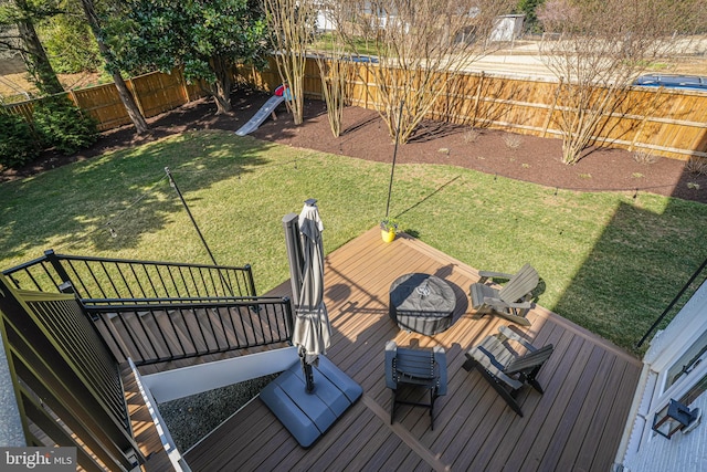 wooden terrace featuring a lawn and a fenced backyard