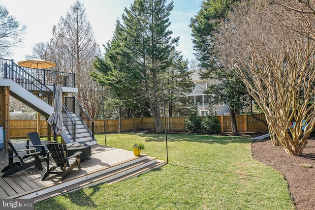 view of yard featuring stairway, a deck, and a fenced backyard