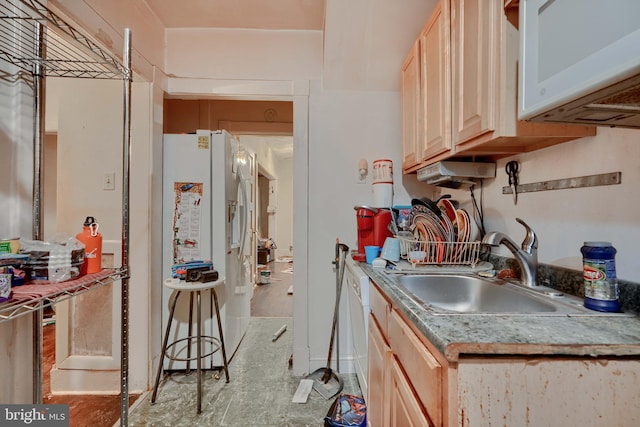 kitchen featuring light brown cabinetry, white appliances, light countertops, and a sink