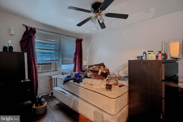 bedroom with cooling unit, a ceiling fan, and wood finished floors