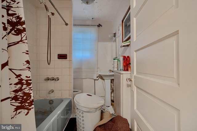 full bath with toilet, shower / tub combo, and a sink