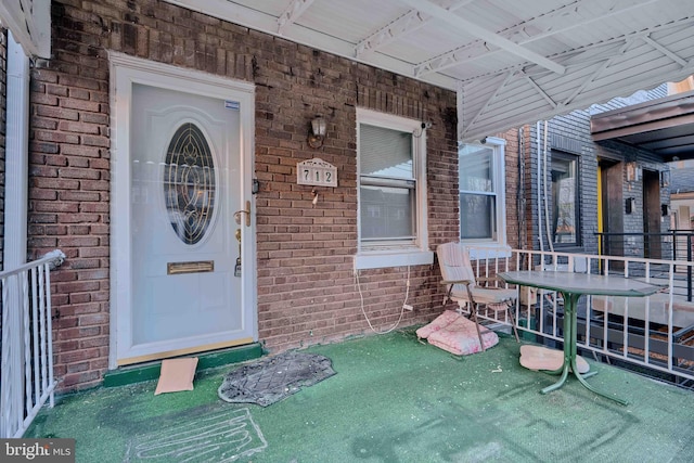 entrance to property featuring brick siding