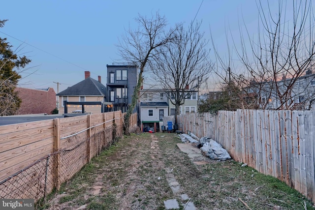 view of yard with a fenced backyard and a garage