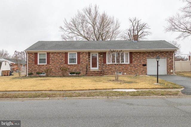 ranch-style house featuring a front yard, fence, driveway, a chimney, and a garage