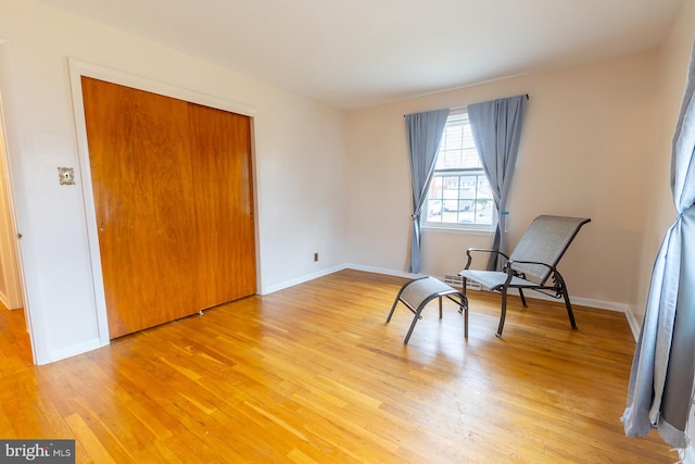 unfurnished room with light wood-type flooring and baseboards