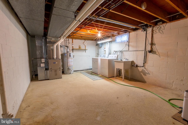 below grade area with heating unit, a sink, gas water heater, and separate washer and dryer