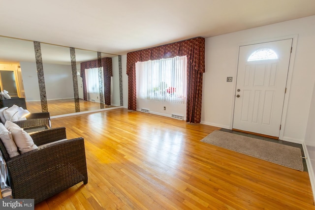 foyer with visible vents, baseboards, and light wood finished floors