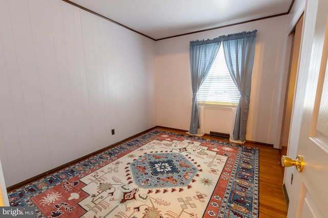 spare room featuring crown molding and wood finished floors