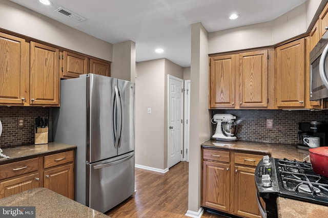 kitchen with visible vents, tasteful backsplash, stainless steel appliances, baseboards, and dark wood-style flooring