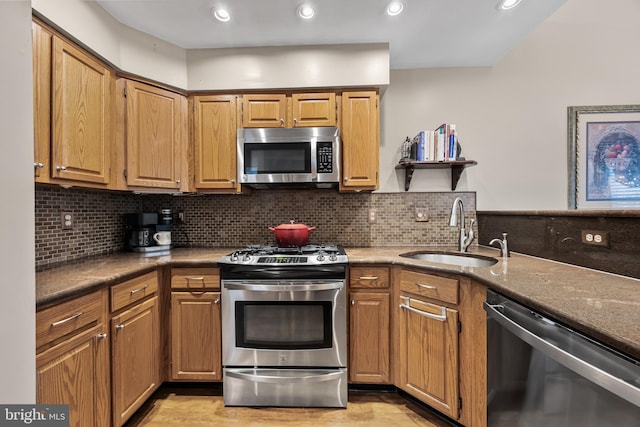 kitchen with a sink, backsplash, appliances with stainless steel finishes, and recessed lighting