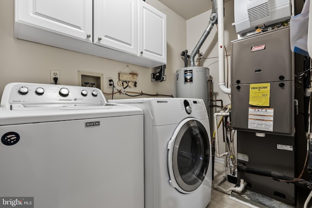 laundry area featuring cabinet space, heating unit, washing machine and dryer, and gas water heater