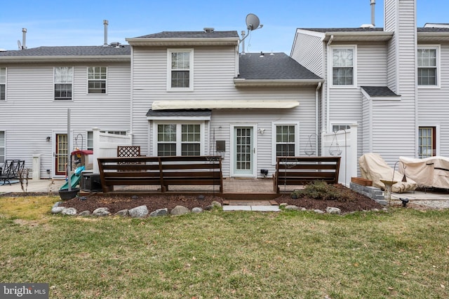 back of property featuring a patio area, a lawn, and a shingled roof