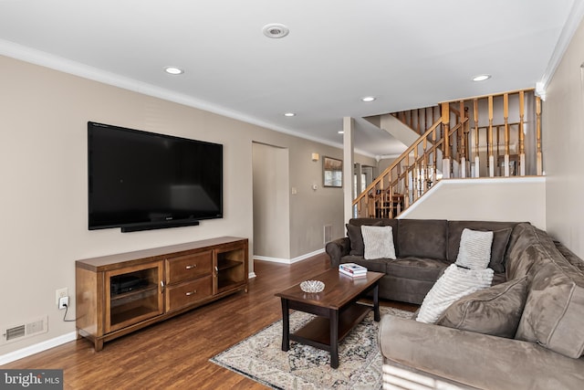 living room with dark wood-style floors, visible vents, baseboards, stairs, and crown molding