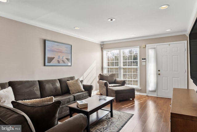 living room with hardwood / wood-style flooring, recessed lighting, crown molding, and baseboards