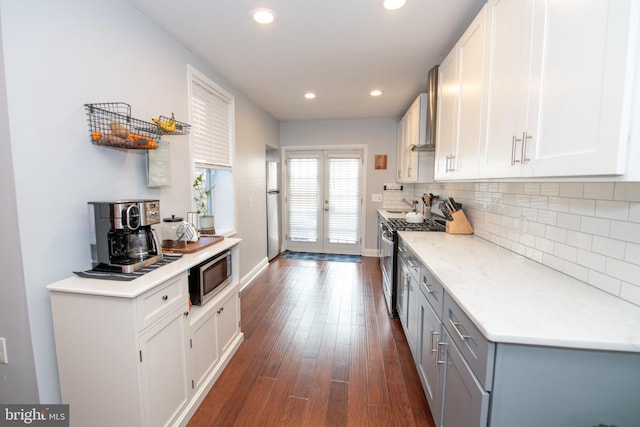 kitchen with tasteful backsplash, dark wood finished floors, recessed lighting, white cabinets, and stainless steel appliances