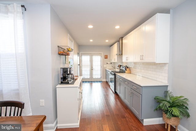 kitchen with gray cabinets, backsplash, wood finished floors, gas stove, and light countertops