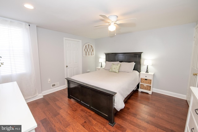 bedroom featuring visible vents, baseboards, dark wood finished floors, and a ceiling fan