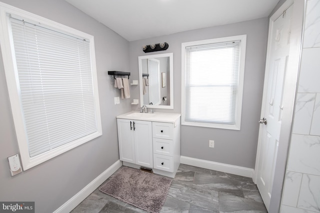 bathroom with vanity, baseboards, and marble finish floor