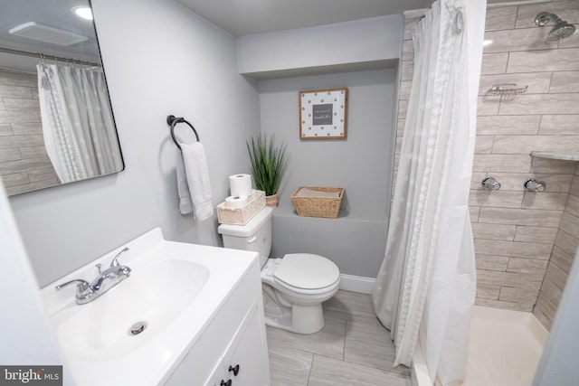 bathroom featuring vanity, toilet, and tiled shower