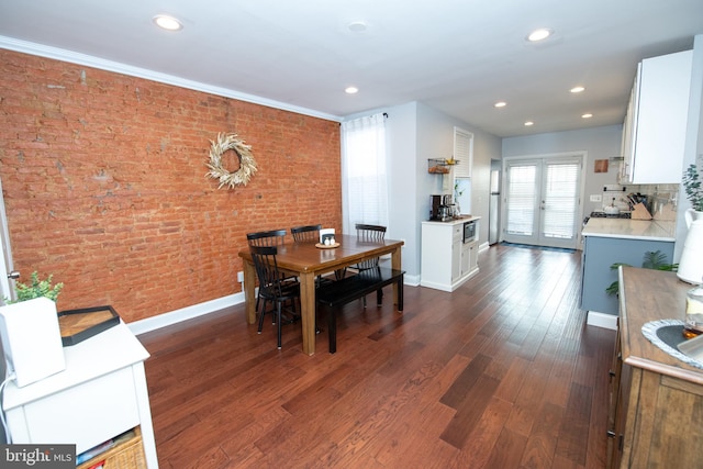 dining area with dark wood-style floors, recessed lighting, brick wall, and baseboards