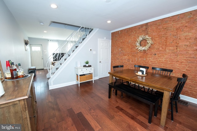 dining space featuring stairway, baseboards, brick wall, dark wood finished floors, and recessed lighting