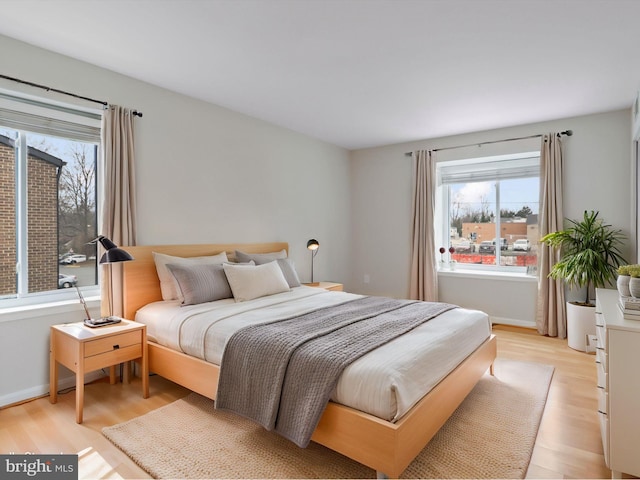 bedroom with baseboards and light wood-style flooring