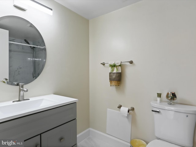 bathroom with baseboards, toilet, vanity, and walk in shower