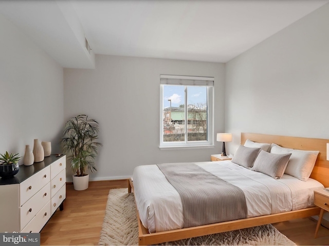 bedroom featuring light wood-type flooring and baseboards