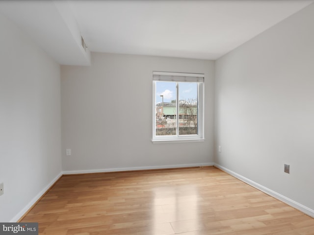 unfurnished room featuring light wood-type flooring and baseboards