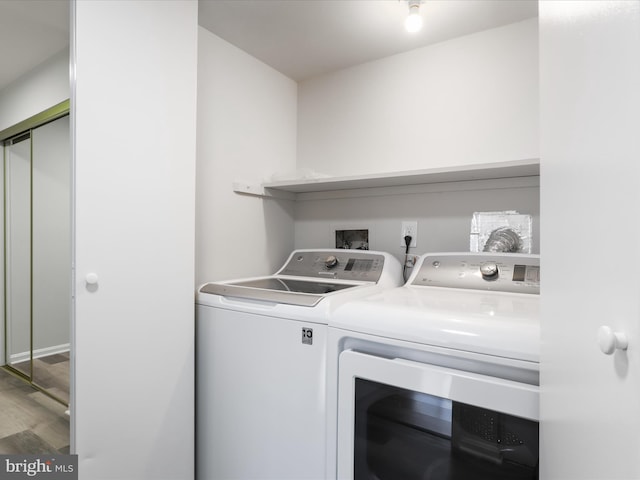 laundry area featuring laundry area, wood finished floors, and separate washer and dryer