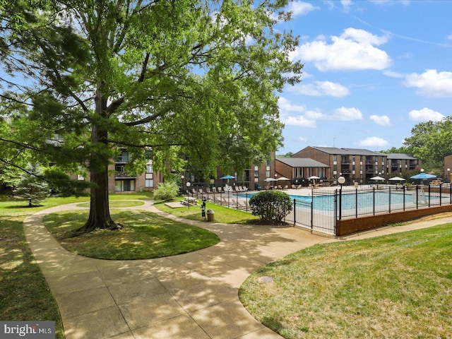 community pool featuring a lawn and fence