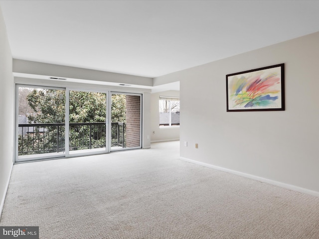 spare room with baseboards, carpet floors, and visible vents