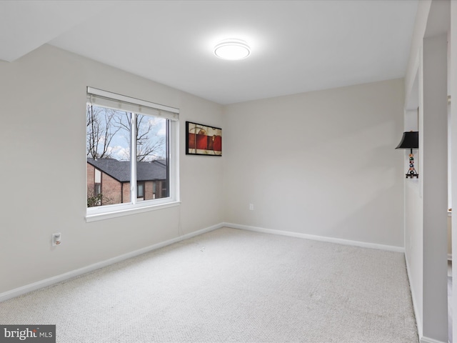 carpeted spare room with baseboards