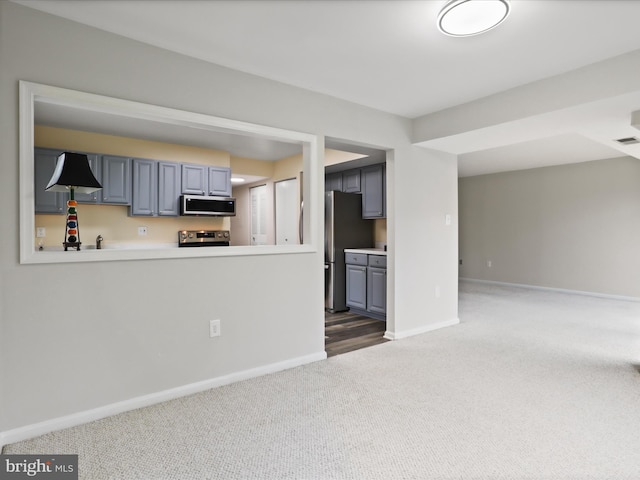 interior space with baseboards, open floor plan, light countertops, carpet floors, and stainless steel appliances