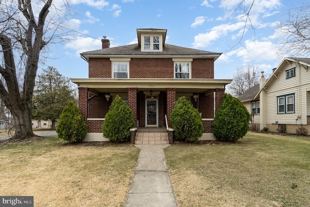 traditional style home with a chimney, brick siding, a porch, and a front lawn