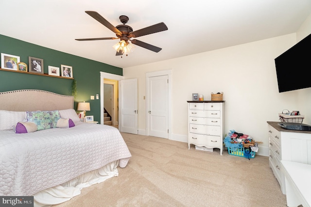 bedroom featuring a ceiling fan and light colored carpet