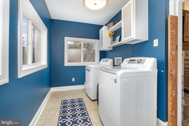 laundry area with light tile patterned floors, cabinet space, independent washer and dryer, and baseboards