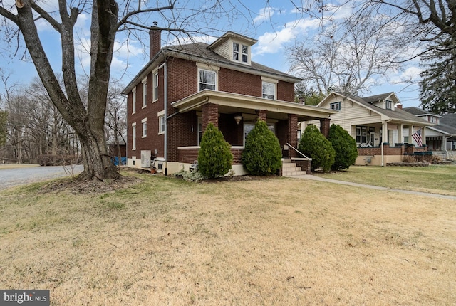 traditional style home with a porch, a front lawn, brick siding, and a chimney