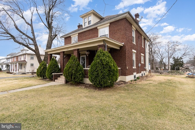 traditional style home featuring a front lawn, brick siding, and a chimney