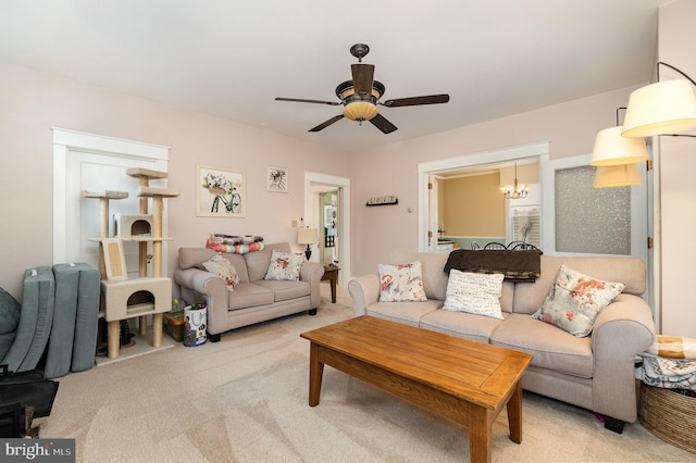 living area featuring ceiling fan with notable chandelier and carpet floors