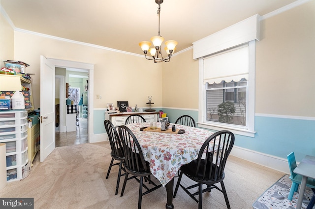 carpeted dining room featuring baseboards, an inviting chandelier, and crown molding