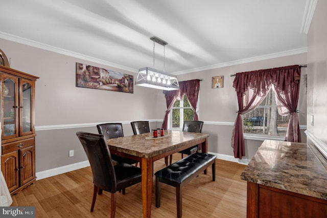 dining area featuring crown molding and light wood-style floors