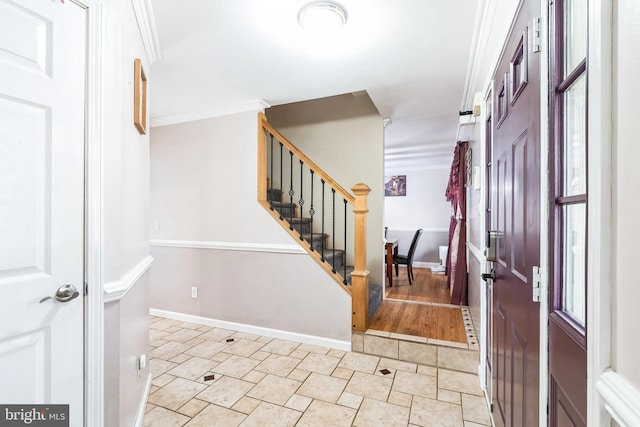 foyer with stairway, baseboards, and ornamental molding