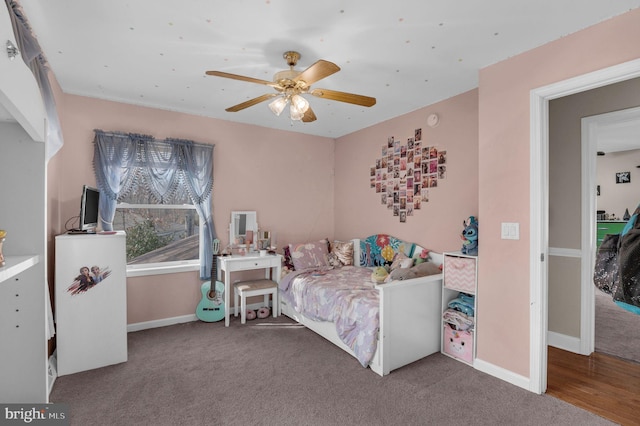 bedroom with a ceiling fan, baseboards, and carpet floors